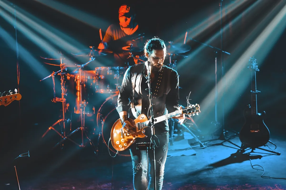 Escenario con haces de luz dramáticos durante un concierto